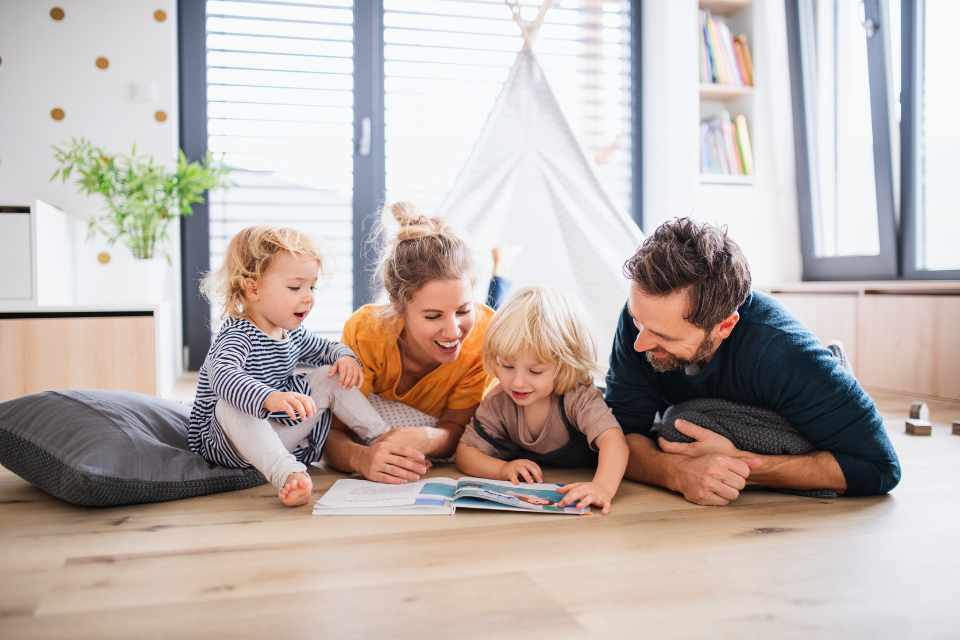family reading book together on newly installed hardwood floors